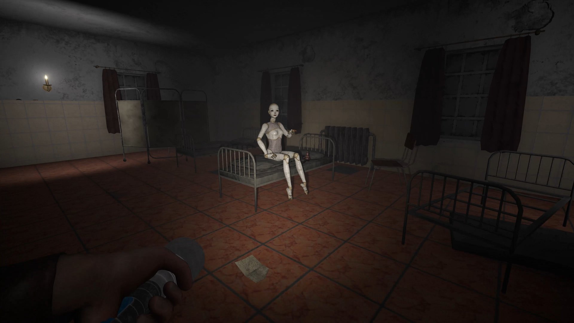 A pale figure sitting on a dormitory bed, torch in hand